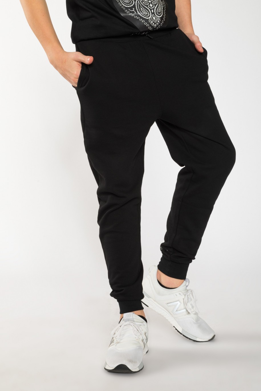 Czarne spodnie dresowe dla chłopaka z nadrukami z tyłu nogawek - 25533