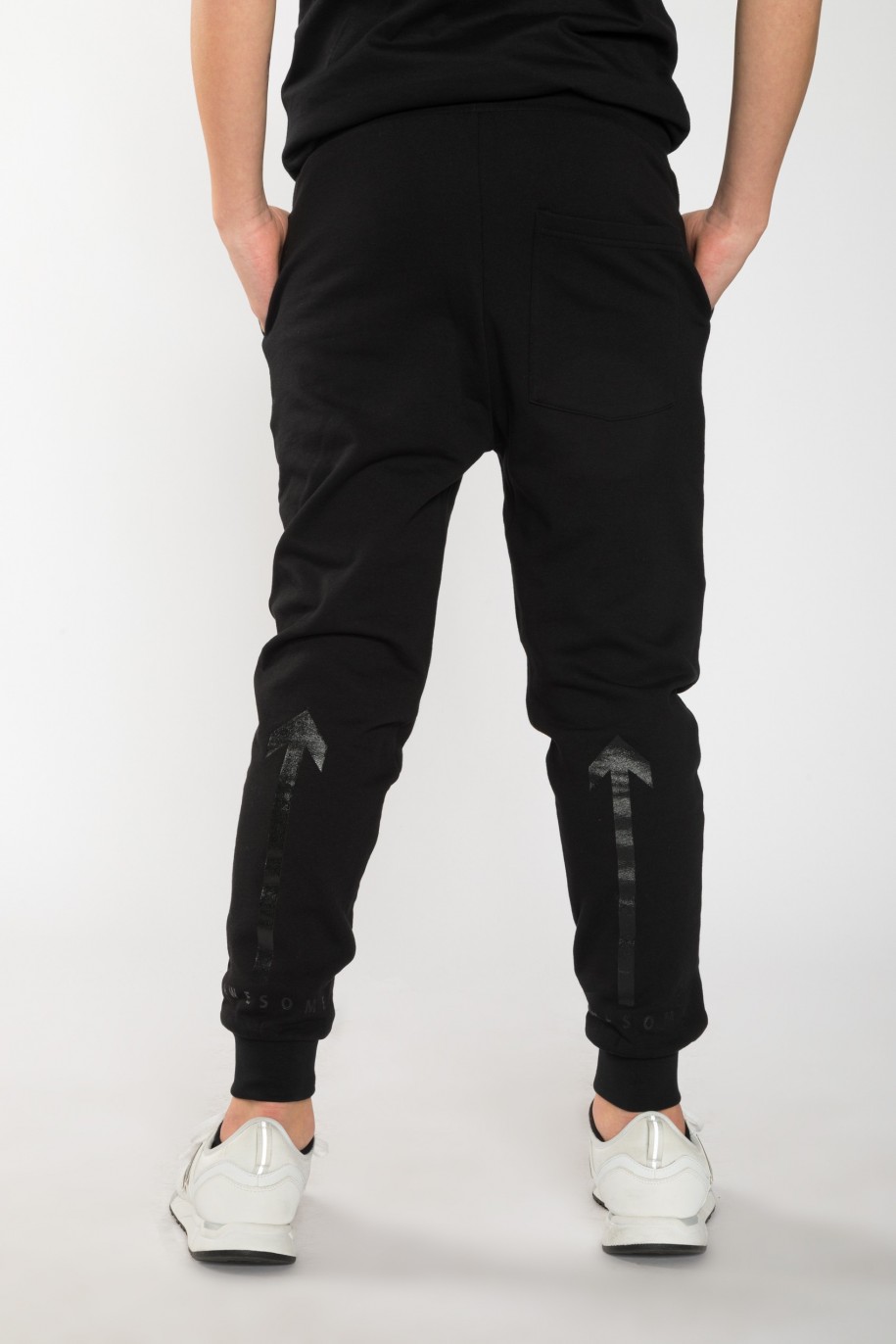 Czarne spodnie dresowe dla chłopaka z nadrukami z tyłu nogawek - 25534