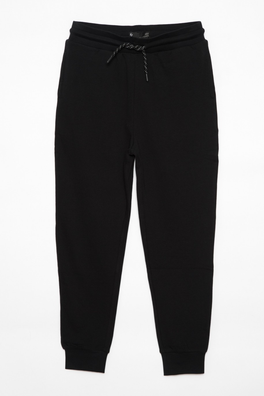 Czarne spodnie dresowe dla chłopaka z nadrukami z tyłu nogawek - 25535