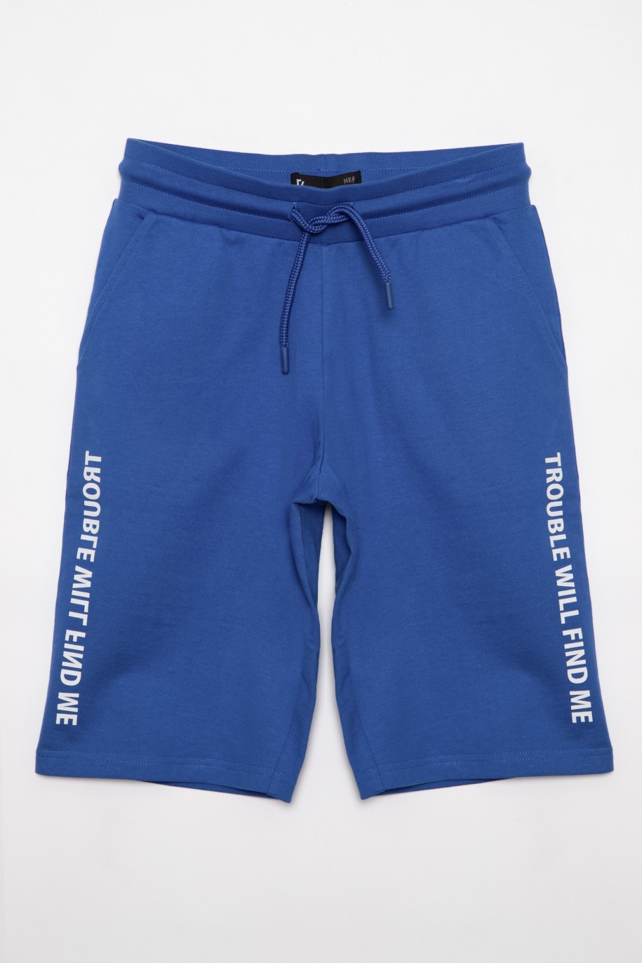 Niebieskie sportowe szorty dla chłopaka z nadrukami na nogawkach - 27068