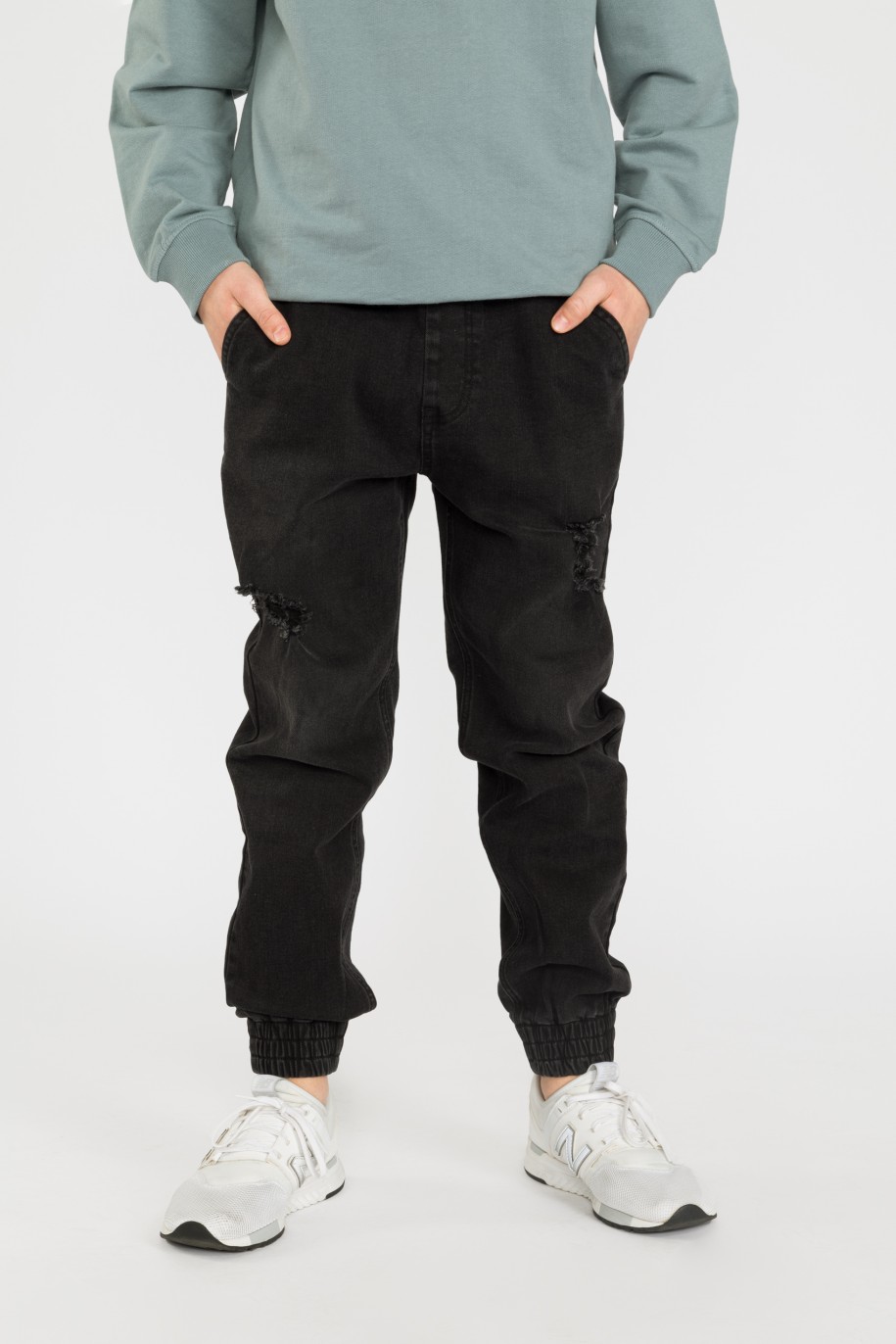 Czarne jeansowe joggery dla chłopaka z modnymi przetarciami - 32467