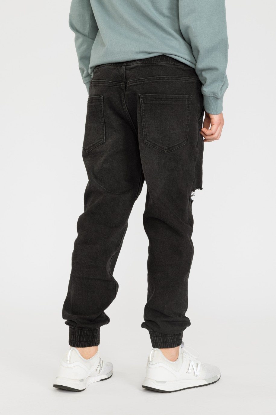 Czarne jeansowe joggery dla chłopaka z modnymi przetarciami - 32468