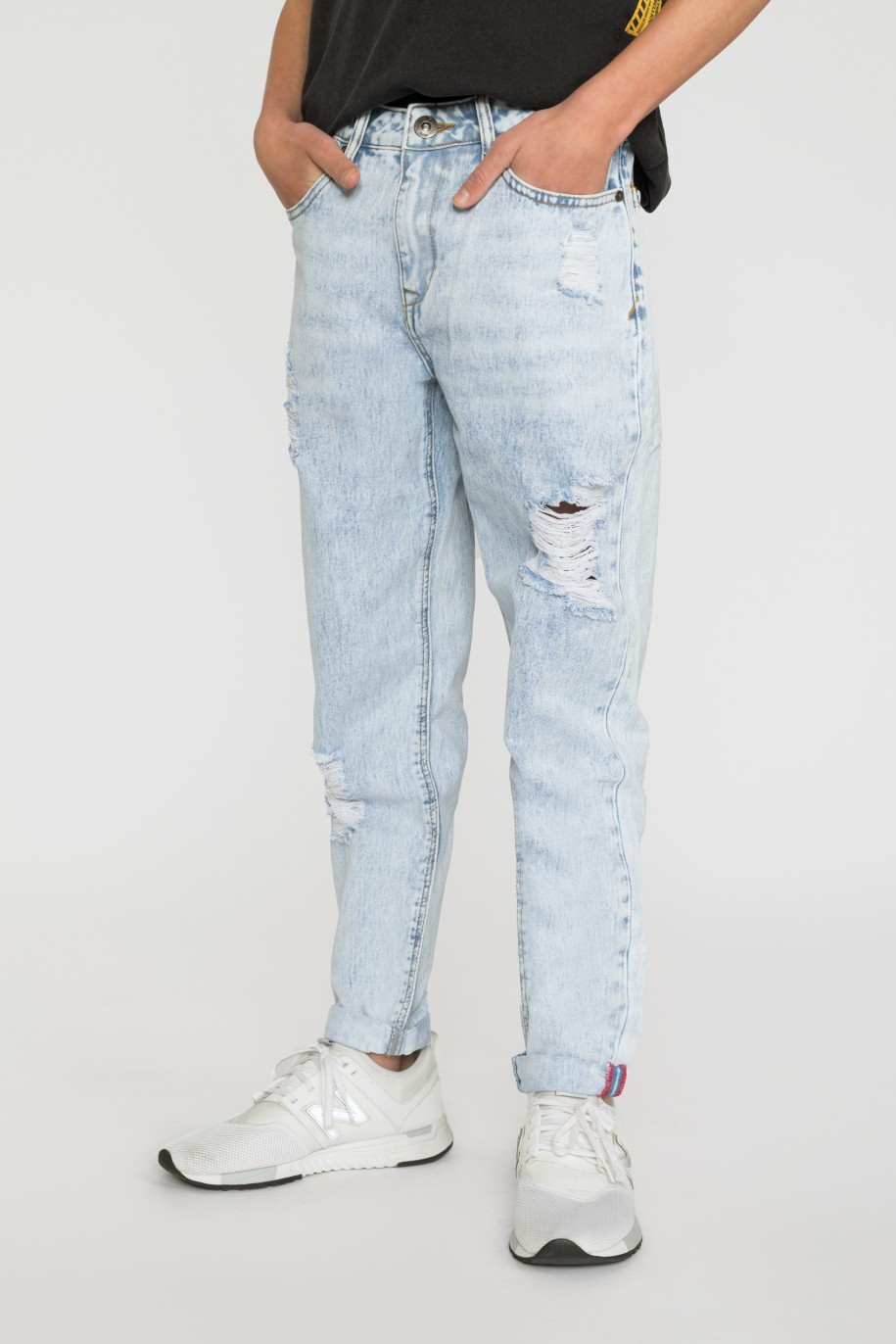 Jasne jeansowe spodnie dla chłopaka z przetarciami - 33190