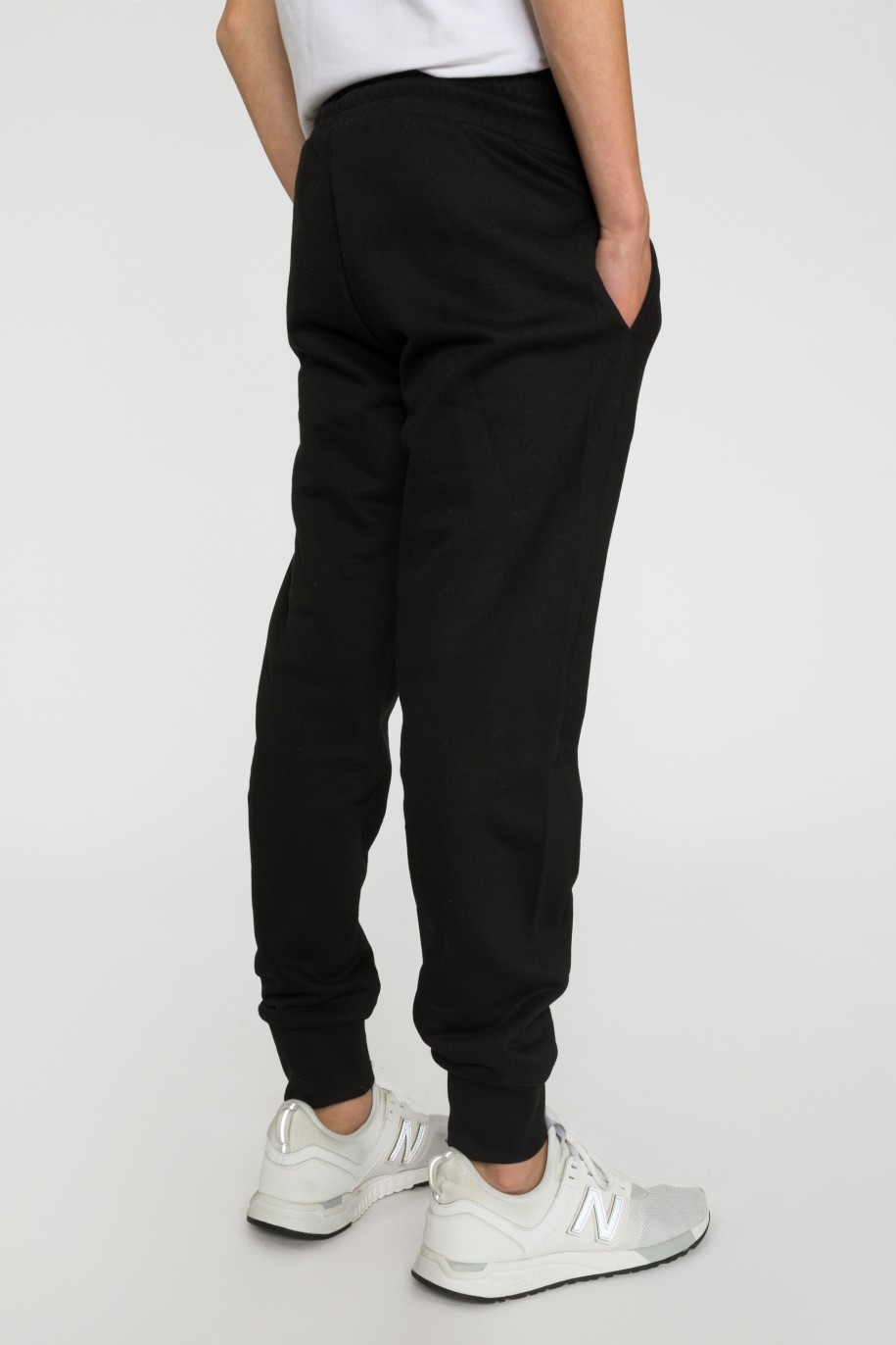 Czarne spodnie dresowe dla chłopaka z gumowymi nadrukami - 33473