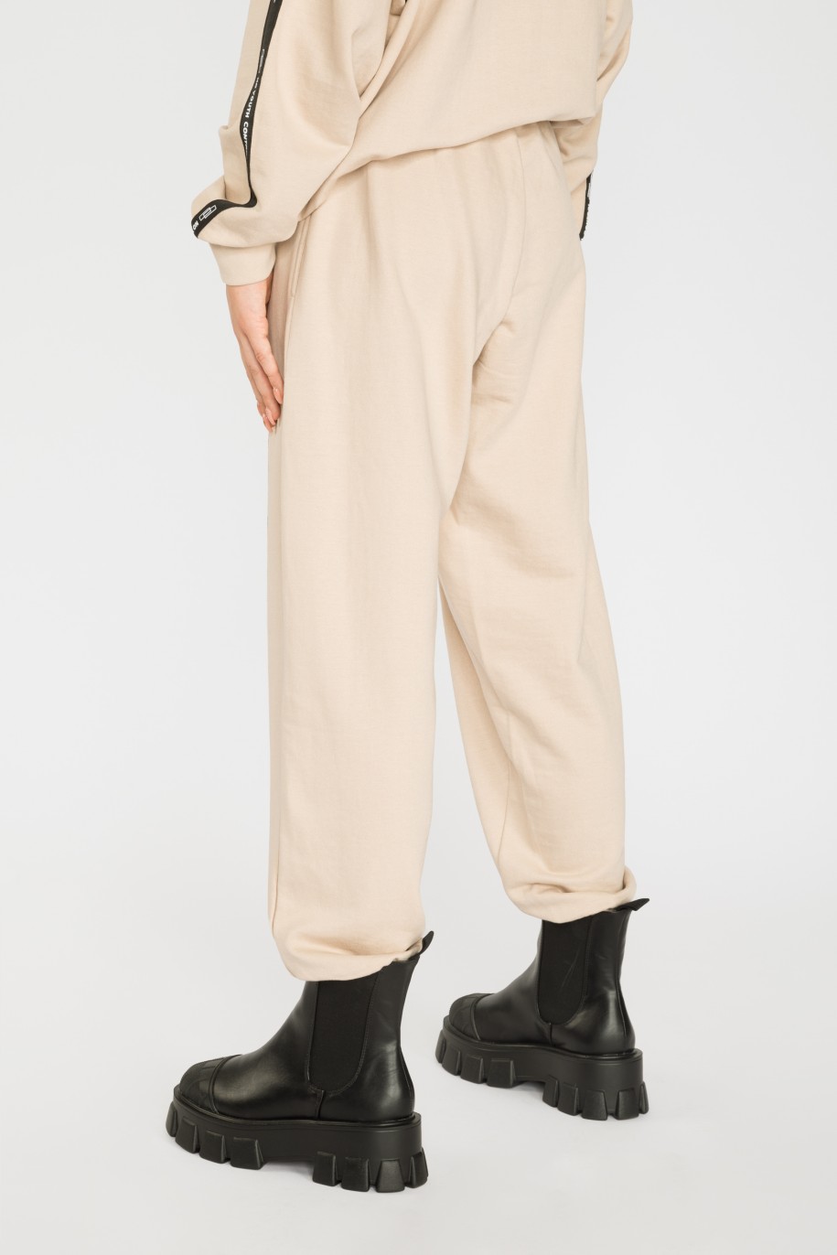 Beżowe spodnie dresowe z ozdobnymi taśmami NO YOUTH CONTROL - 37695