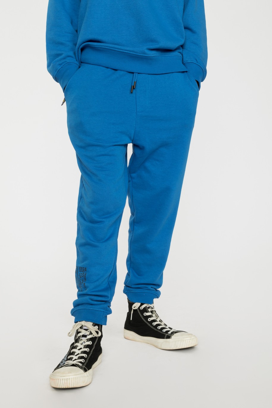 Niebieskie spodnie dresowe z napisami na nogawce - 37848