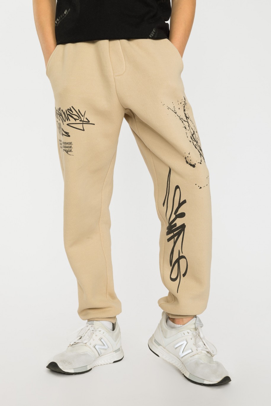 Beżowe spodnie dresowe oversize z nadrukami - 40160
