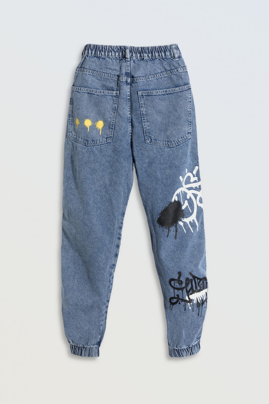 Niebieskie jeansy typu joggery z nadrukami na nogawkach - 45690