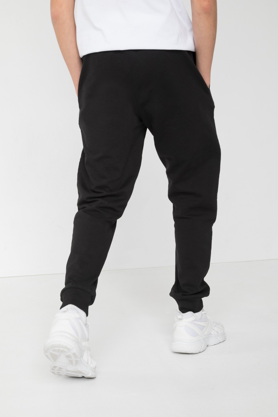 Czarne spodnie dresowe z nadrukiem na nogawce - 45907