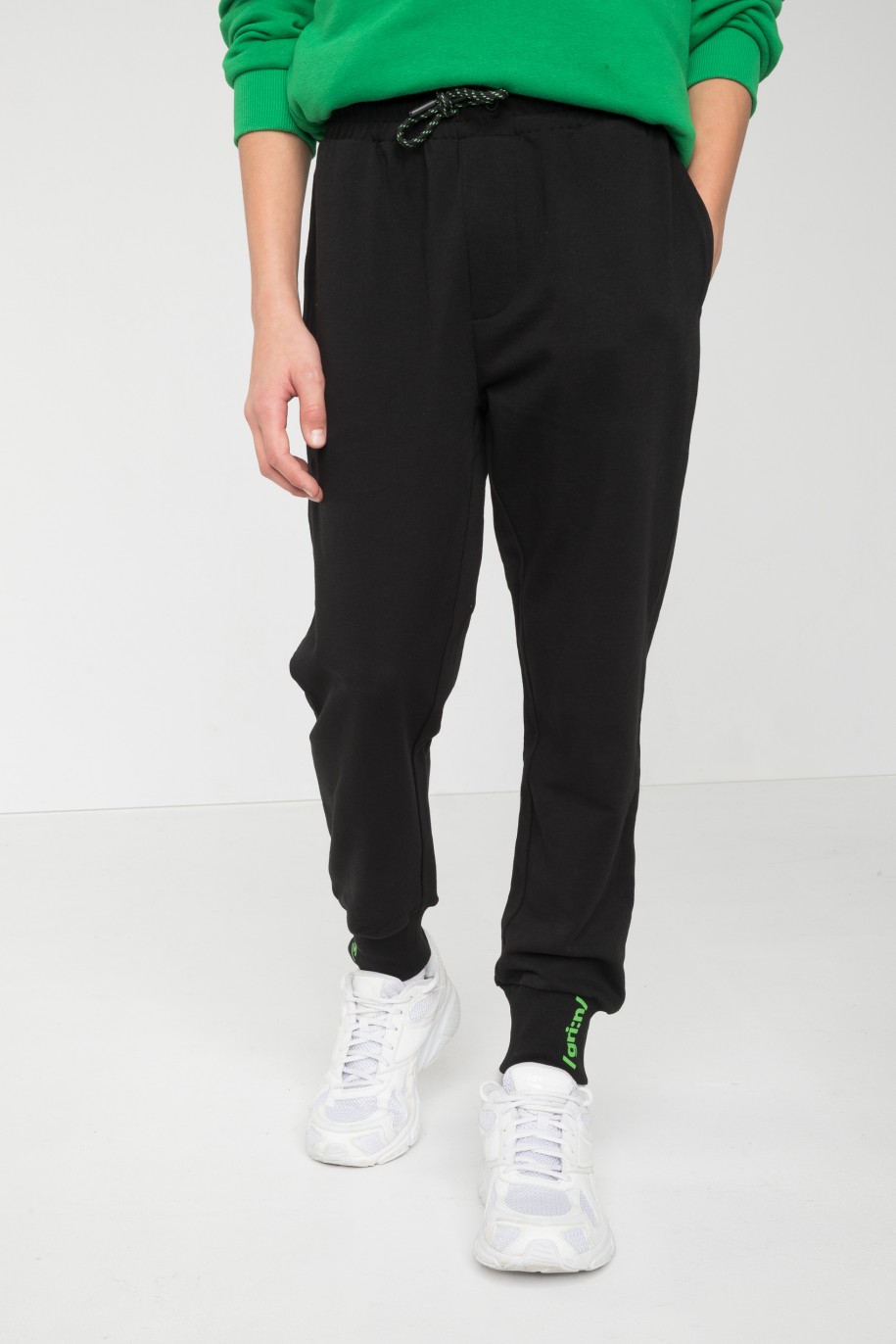 Czarne spodnie dresowe z minimalistycznym nadrukiem na ściągaczach - 45916