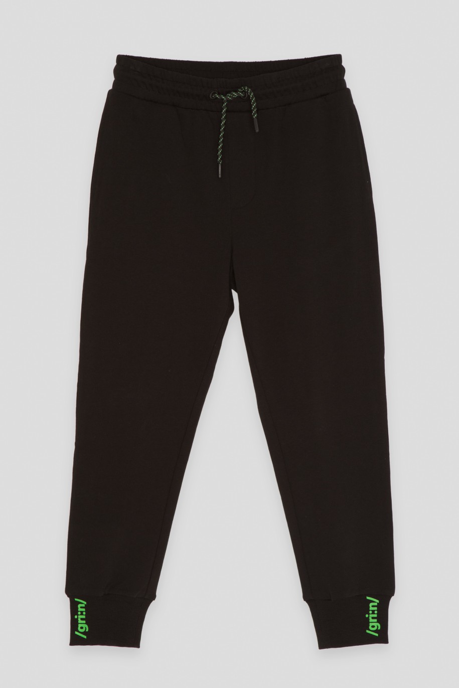 Czarne spodnie dresowe z minimalistycznym nadrukiem na ściągaczach - 45917