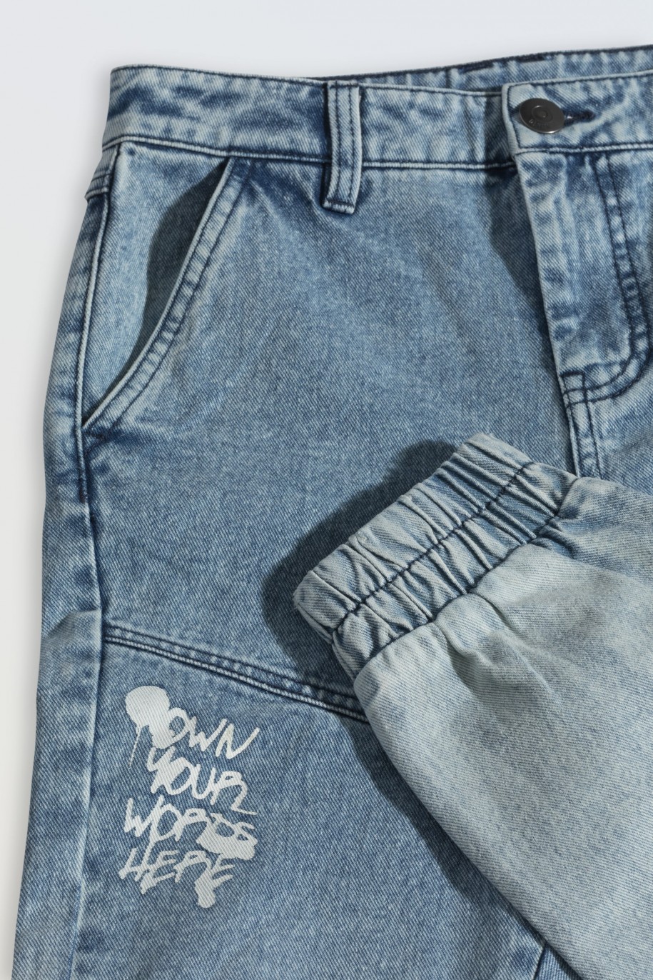 Niebieskie spodnie jeansowe typu joggery z nadrukami na nogawkach - 46555
