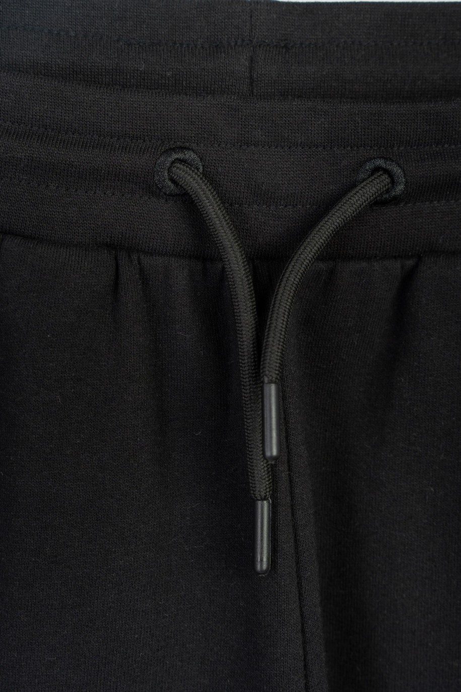 Czarne spodnie dresowe z hologramowym nadrukiem na nogawce - 47265