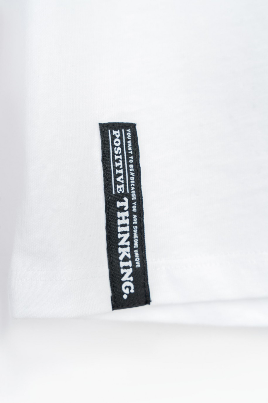 Biały t-shirt oversize z minimalistyczną naszywką - 47336